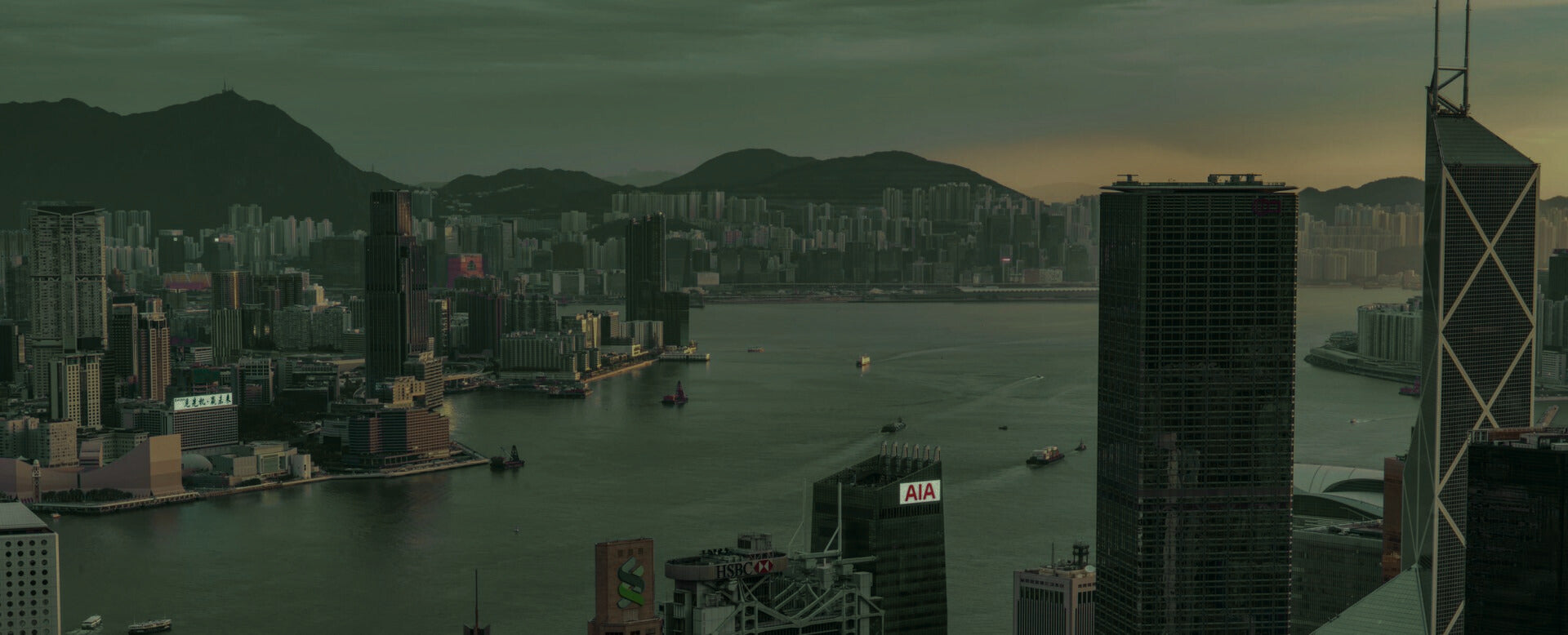 Cityscape with tall buildings and a body of water at dusk in mm Multi Fuel brand color.