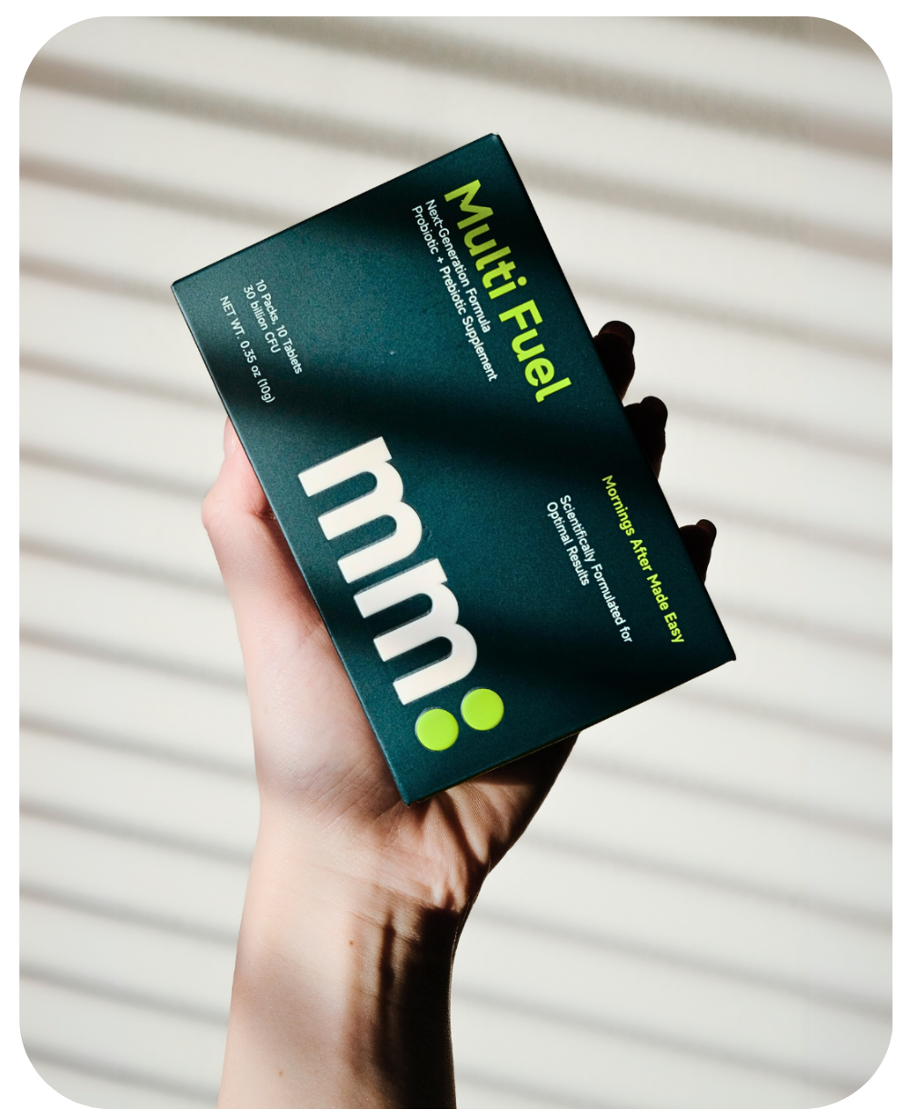 Hand holding a box of mm Multi Fuel against a neutral background
